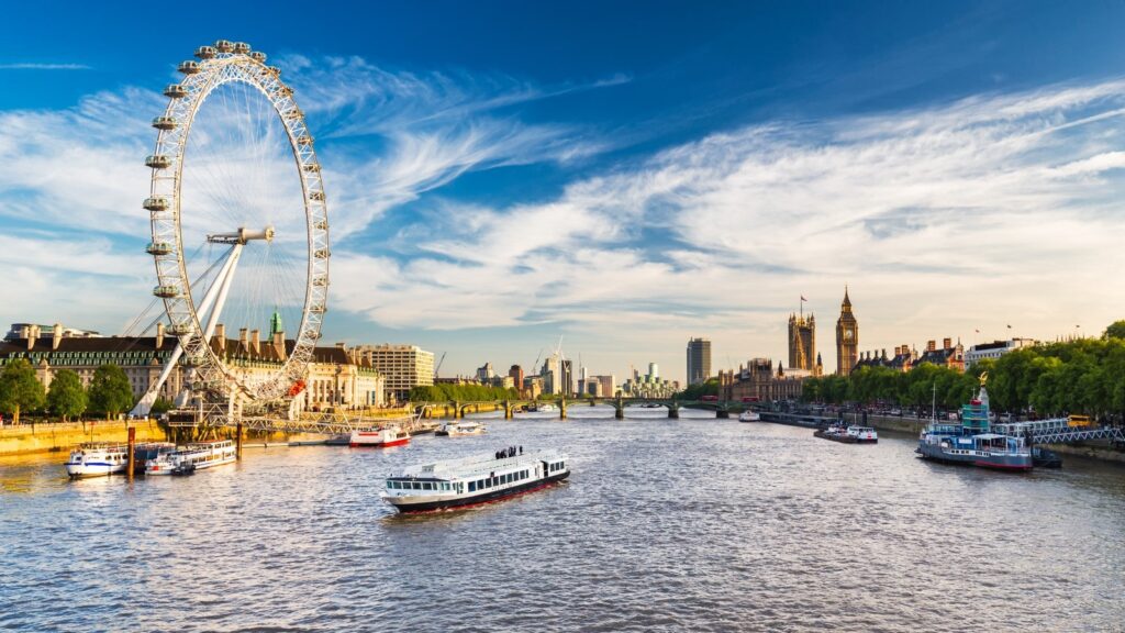 A river with a ferris wheel and a city in the background